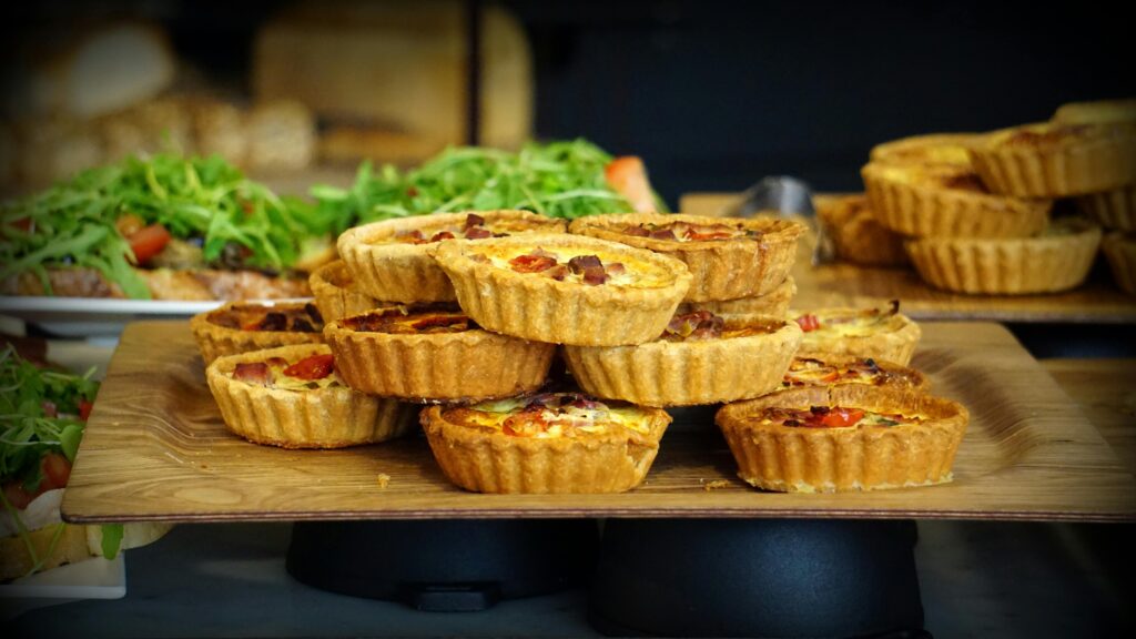 pexels-photo-109836-109836 A tempting display of homemade quiches topped with fresh ingredients on a wooden tray.